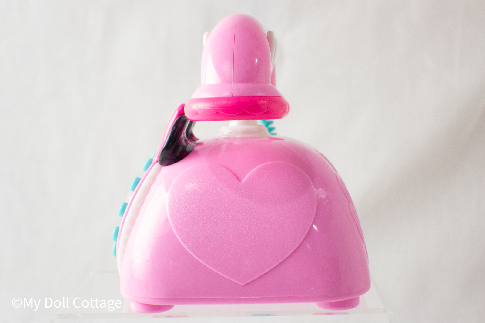 Side profile showing the handset on its cradle and turquoise curly cord attached.