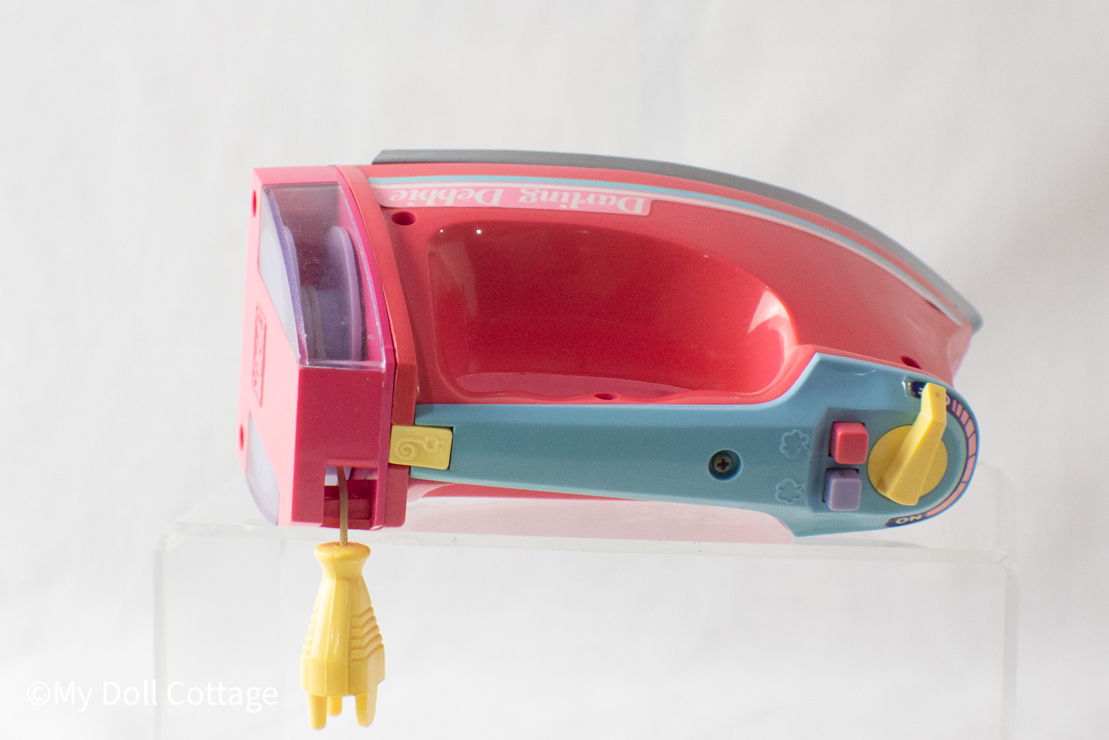 Top-down view of the control panel featuring a yellow rotary dial and two moulded buttons.