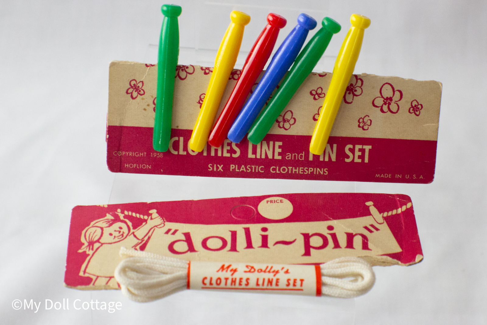 •	Front view of the Dolli-Pin clothesline set showing six colourful pins attached to the original 1958 backing card.