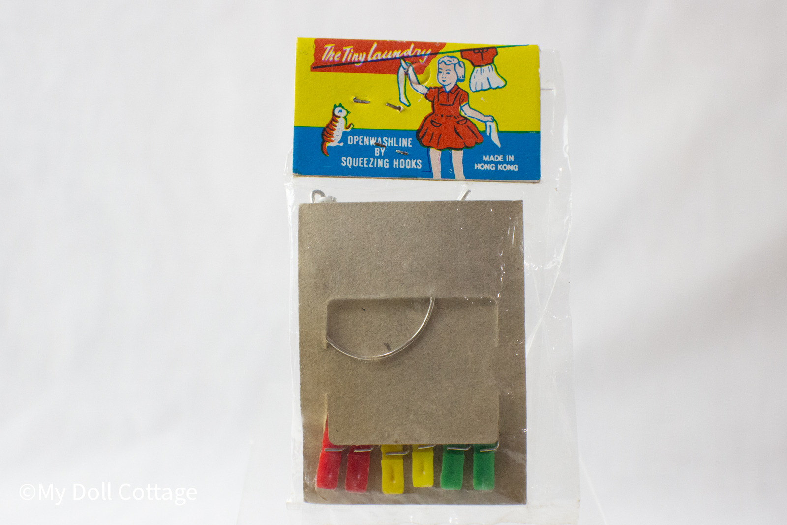 2.	Rear view of the packaged clothesline set displaying the cardboard backing and peg arrangement.