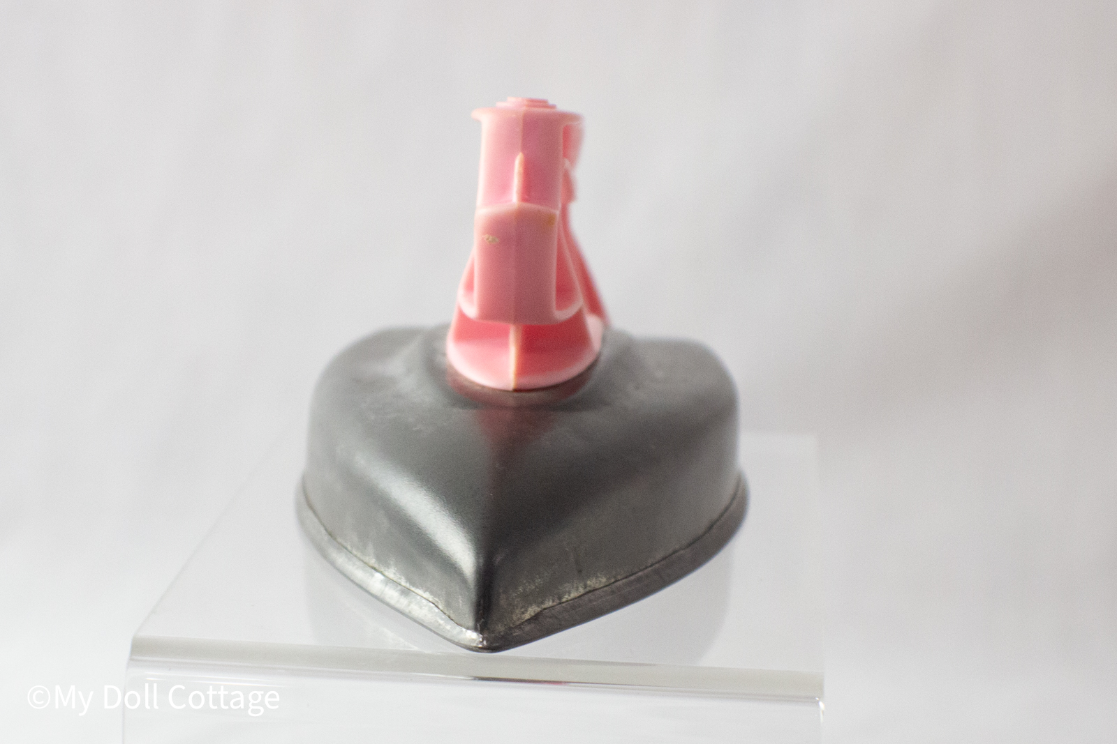 Front view of the vintage Wolverine Toy iron with a pointed metal tip and pink handle visible.