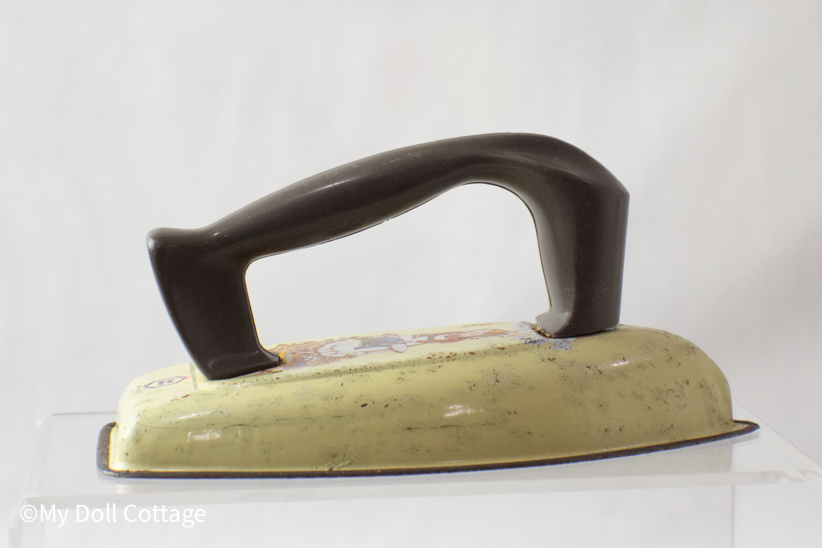 Angled view showing the Holly Hobbie artwork and aged tin surface with tarnish.