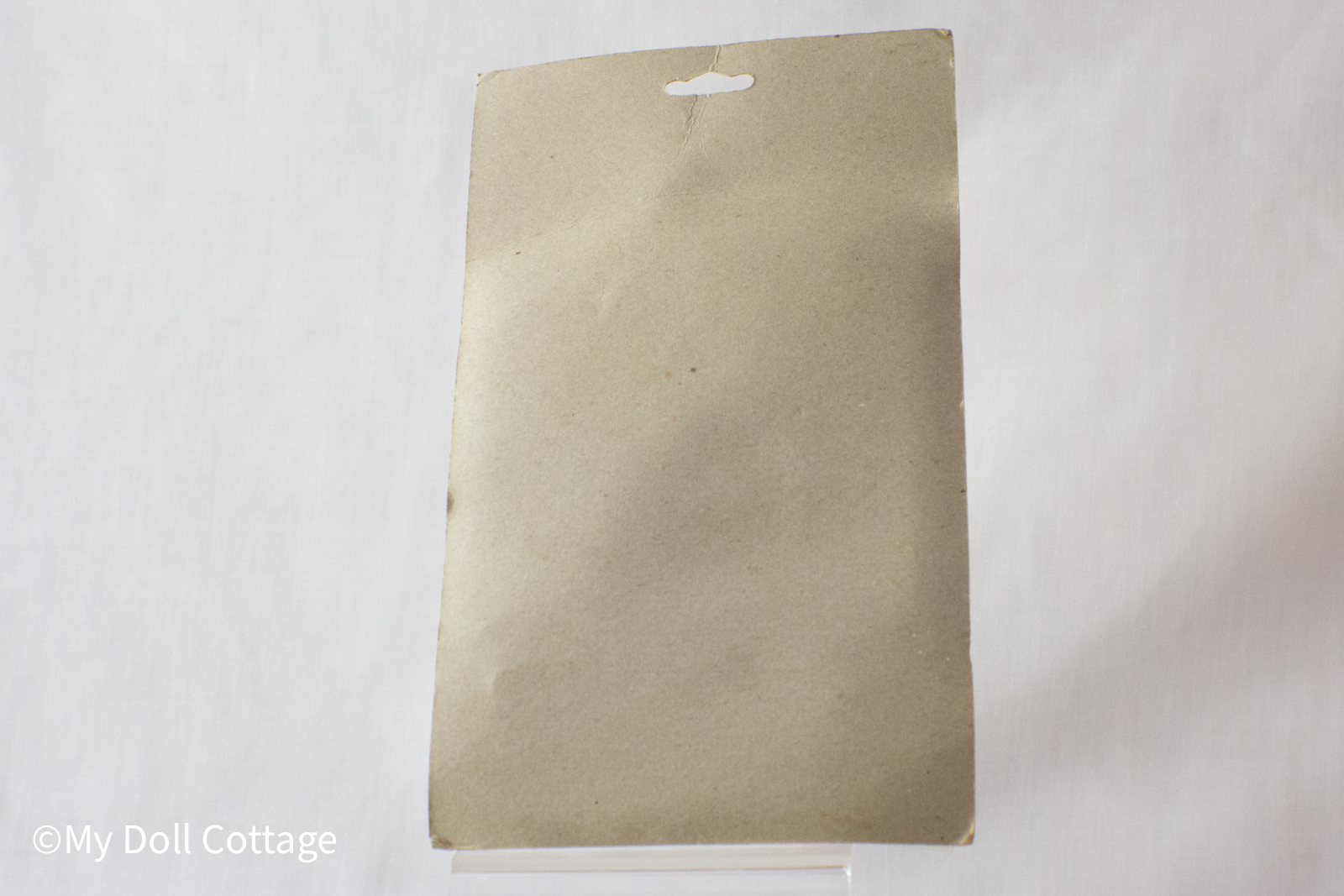 Back of the rubber band gun packaging showing plain brown cardboard backing, slightly creased at the top.