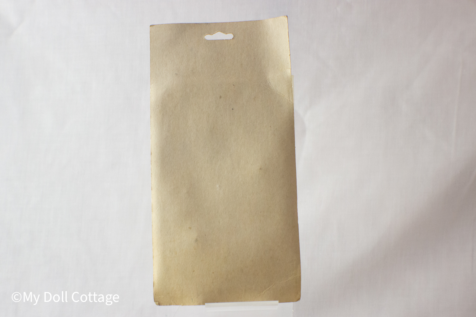 Rear view of the 1970s Safety Pop Pistol Target Set showing the plain brown cardboard backing of the original packaging.