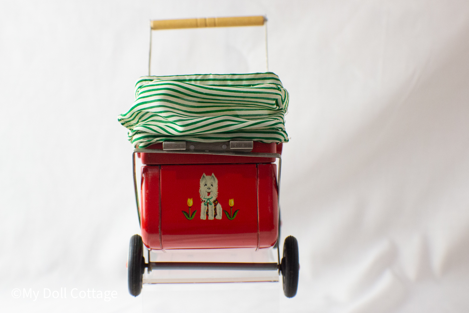 Rear view of tin pram with lithographed Scottie dog and yellow tulip design.