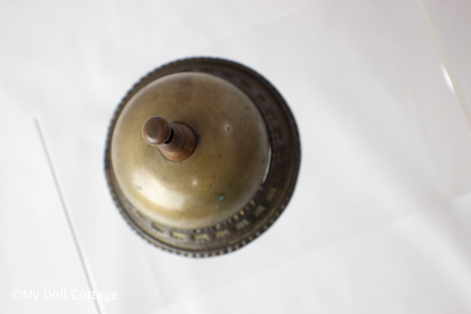 Angled top view of brass bell highlighting patina and rounded shape.