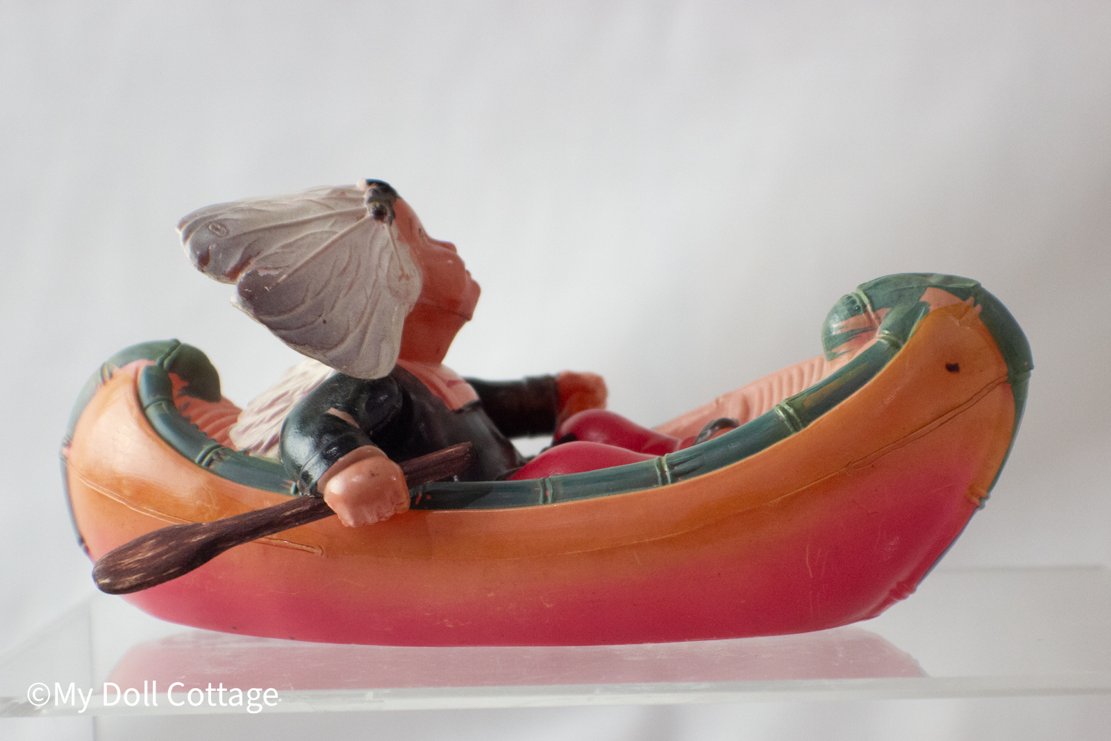 Opposite side view: Figure holding oar, showing canoe colouring and details.