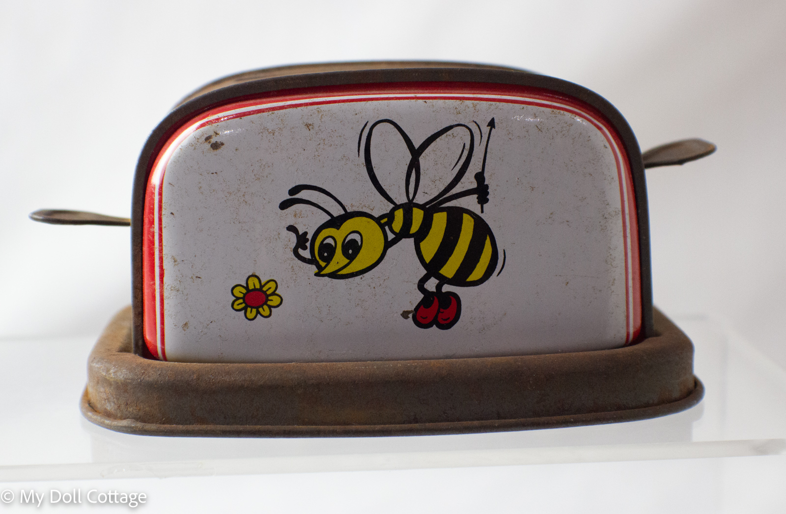 Rear view of tin toy toaster with spring mechanism opening