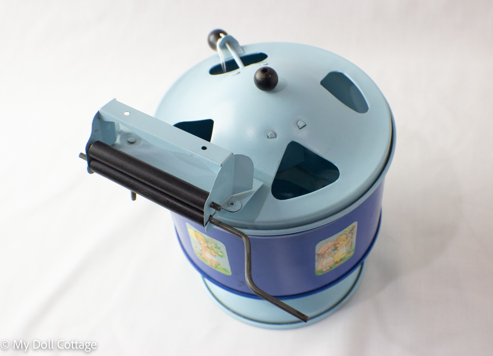 Blue 1930s tin lithographed toy washing machine with domed lid and hand crank.
