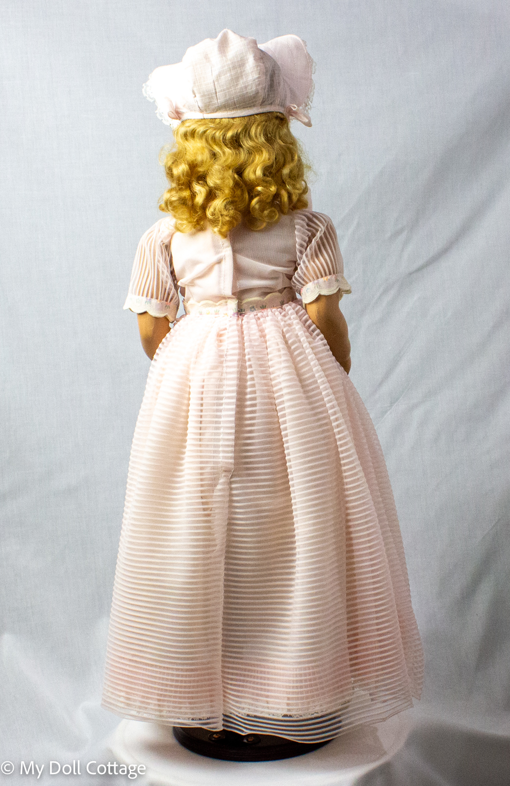Full front view of Barwood Joanne walker doll in pink dress and bonnet