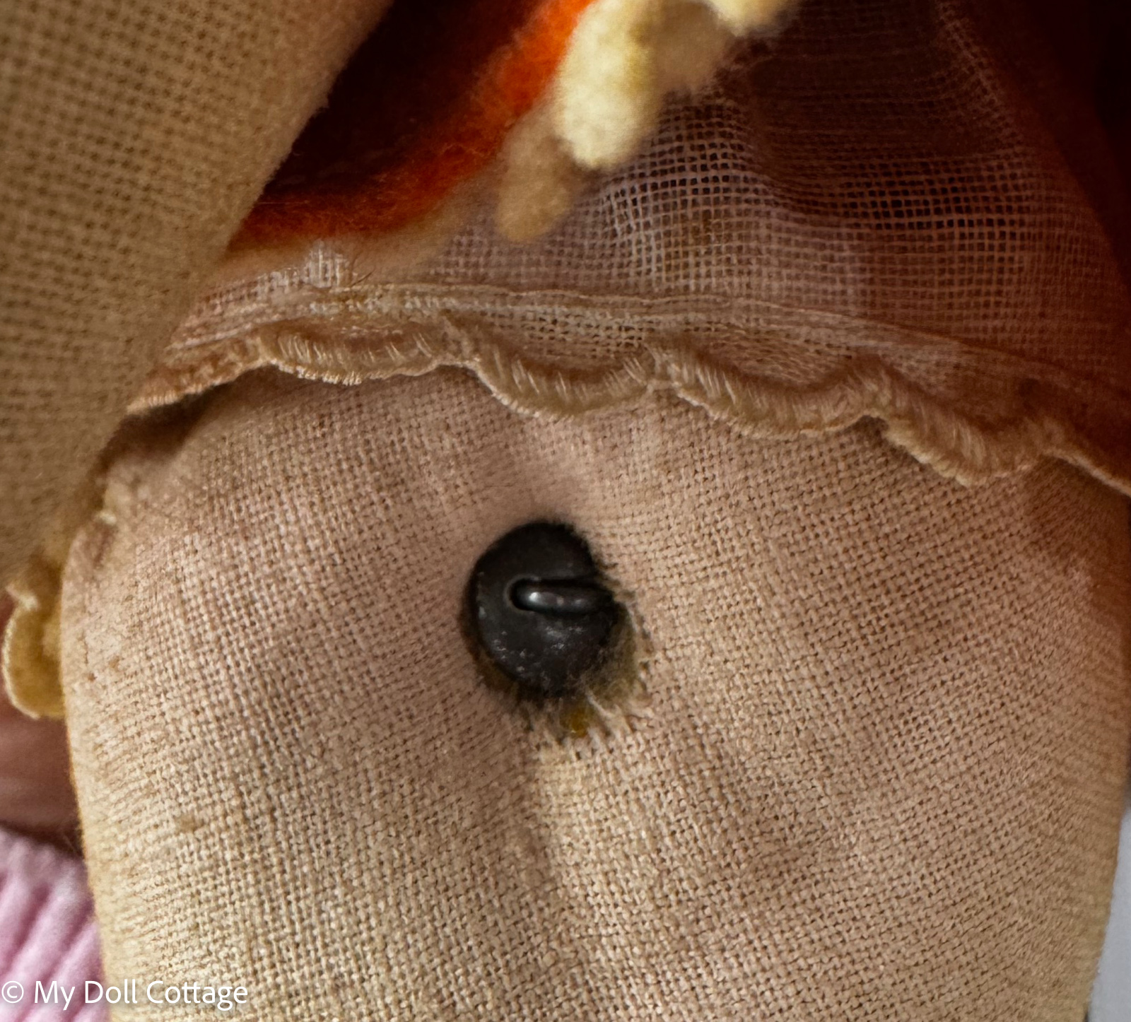 Close-up of original cloth body attachment and metal fastening beneath costume.