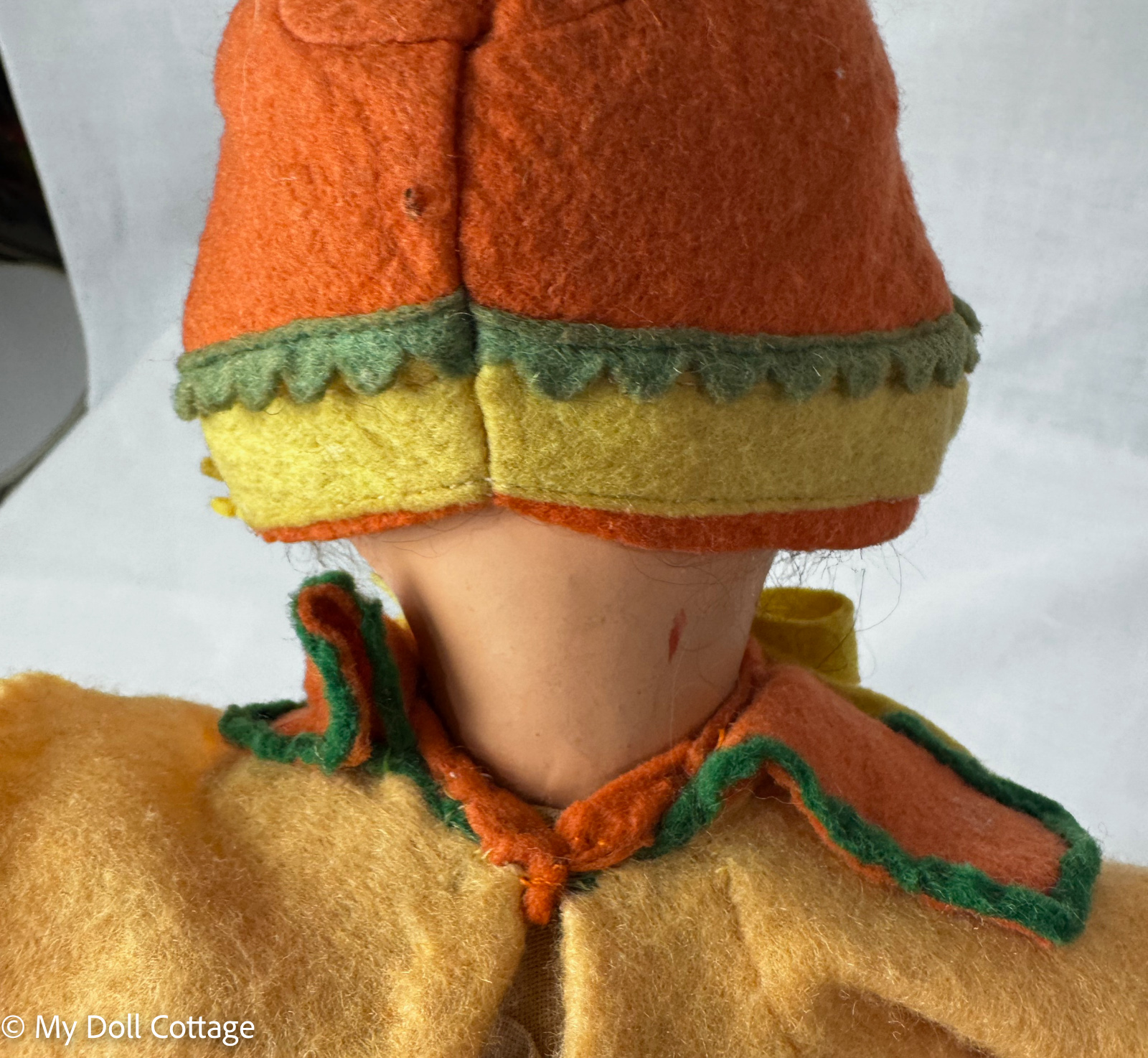 Rear view of felt bonnet and costume showing original stitching and trim detail.