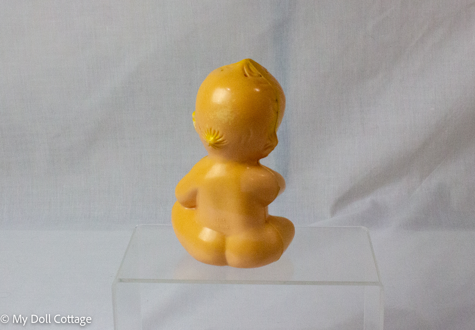 3. Rear view of vintage JSNY Hong Kong Kewpie dispenser showing faded plastic and moulded hair detail.