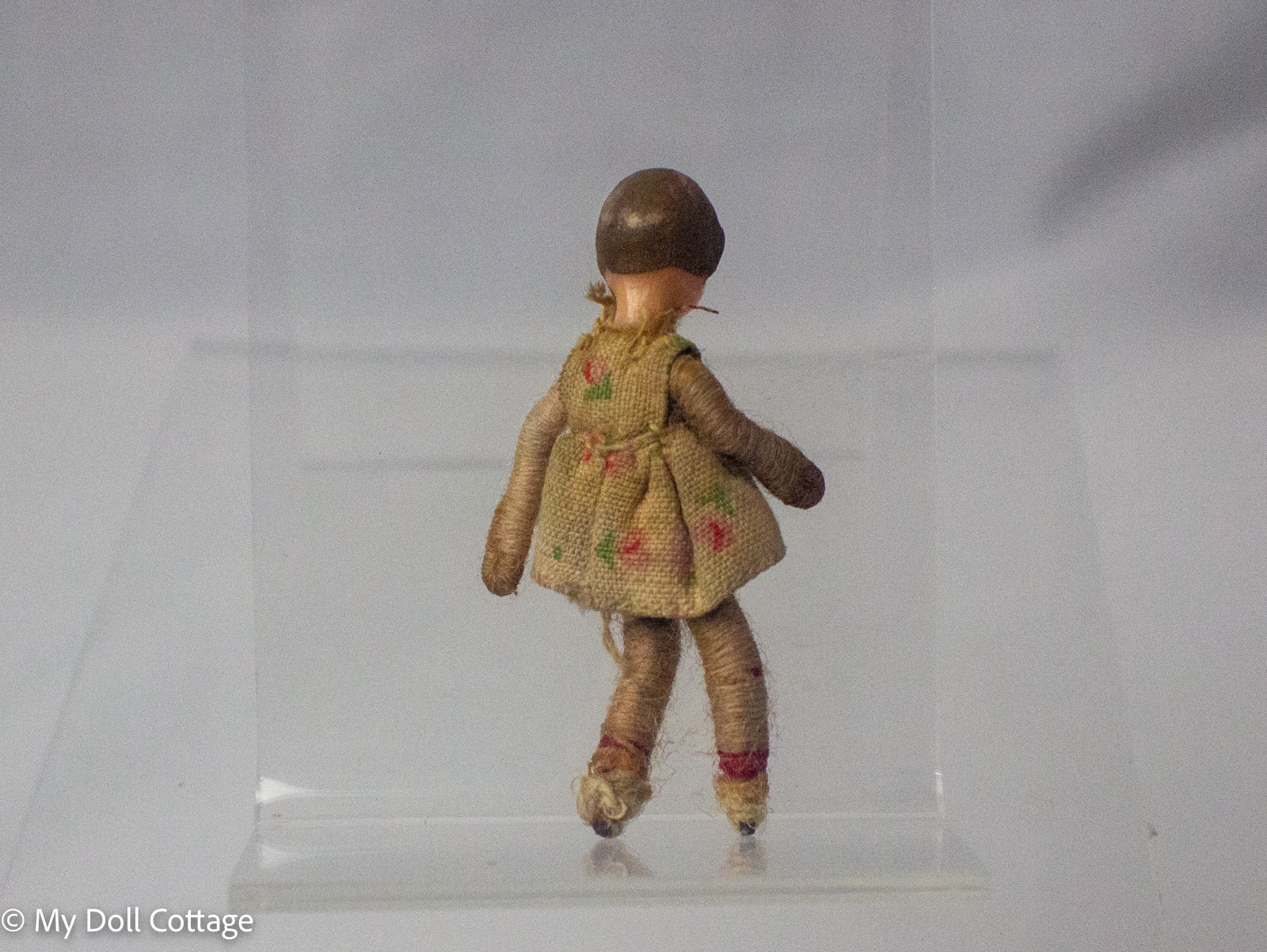 2. Close-up view of tiny handcrafted folk-style doll with painted facial features and wrapped body.