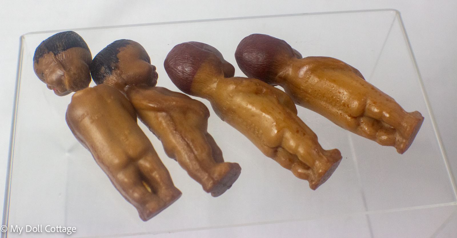 6. Rear view of miniature Austrian wax dolls showing moulded hair and body details.