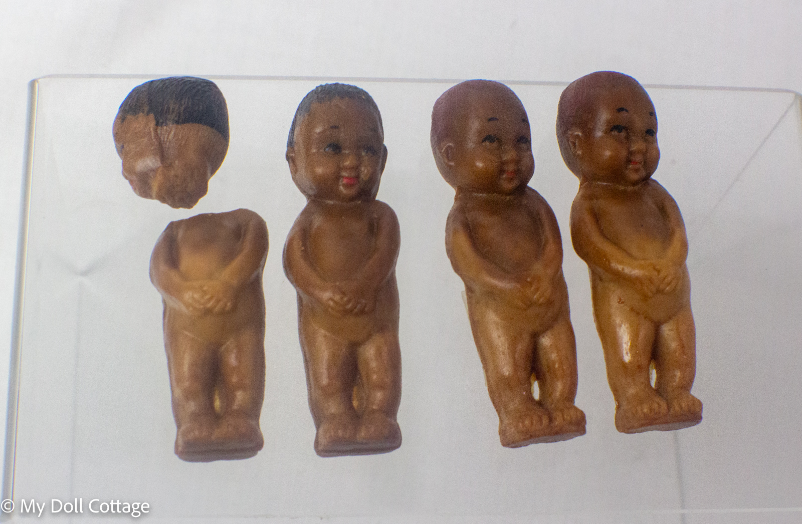5. Individual miniature wax Kewpie-style dolls removed from original box.