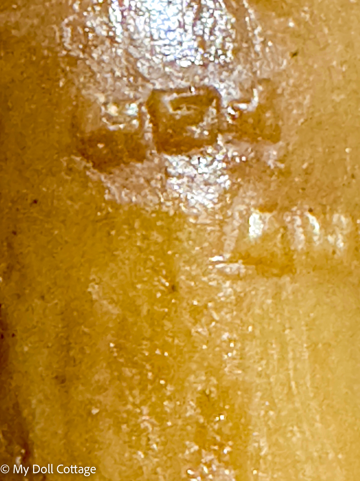 3. Macro photograph showing MEM Vienna maker’s mark on wax doll surface.