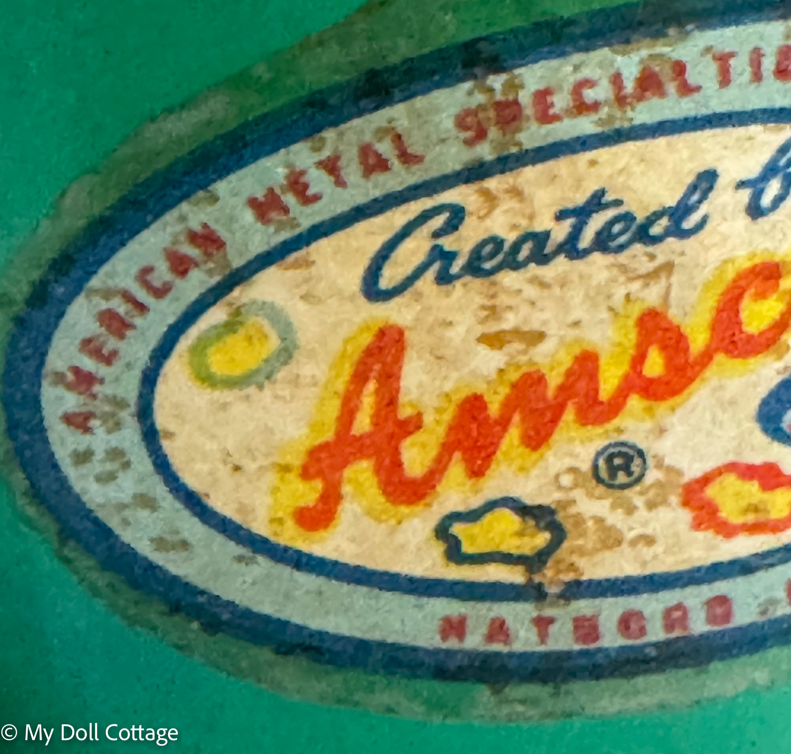 1. Close-up of embossed “Amsco” marking and bottle measurements on miniature glass feeding bottle.