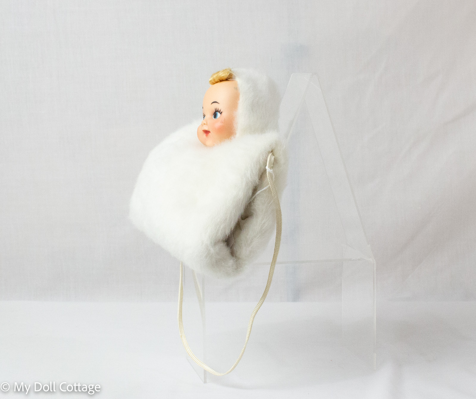 Angled side view highlighting doll face and fur hood