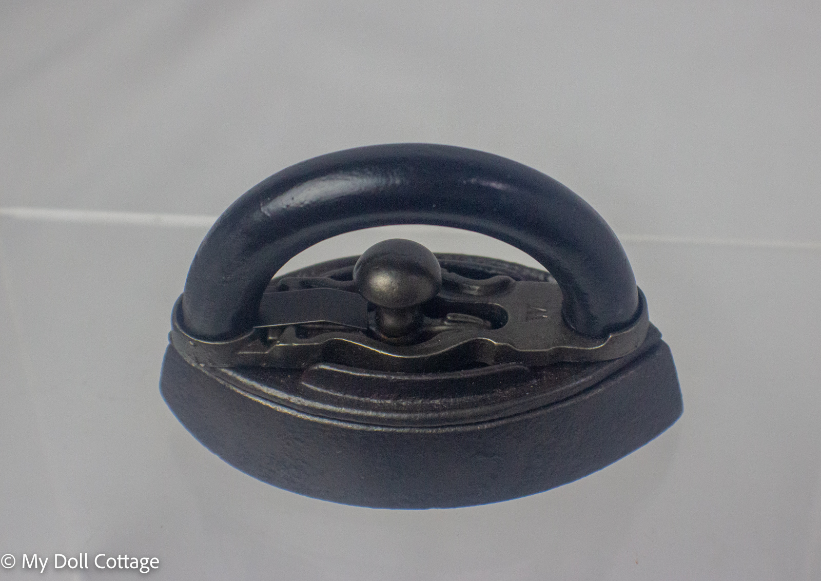 Angled side view highlighting the elegant curved handle and compact cast iron base.