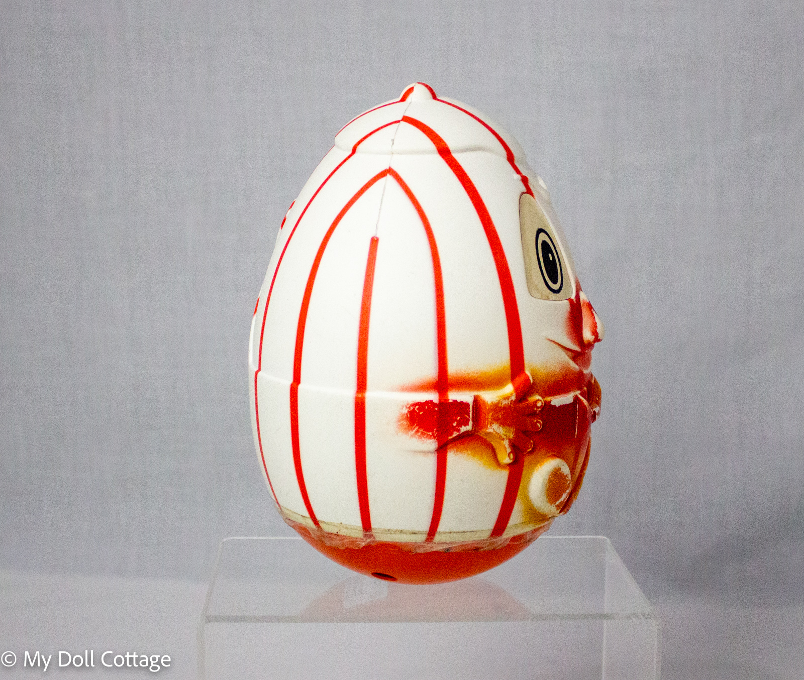 Side view of c.1970s Humpty Dumpty rocking toy showing its rounded egg-shaped profile, striped decoration and central body seam.
