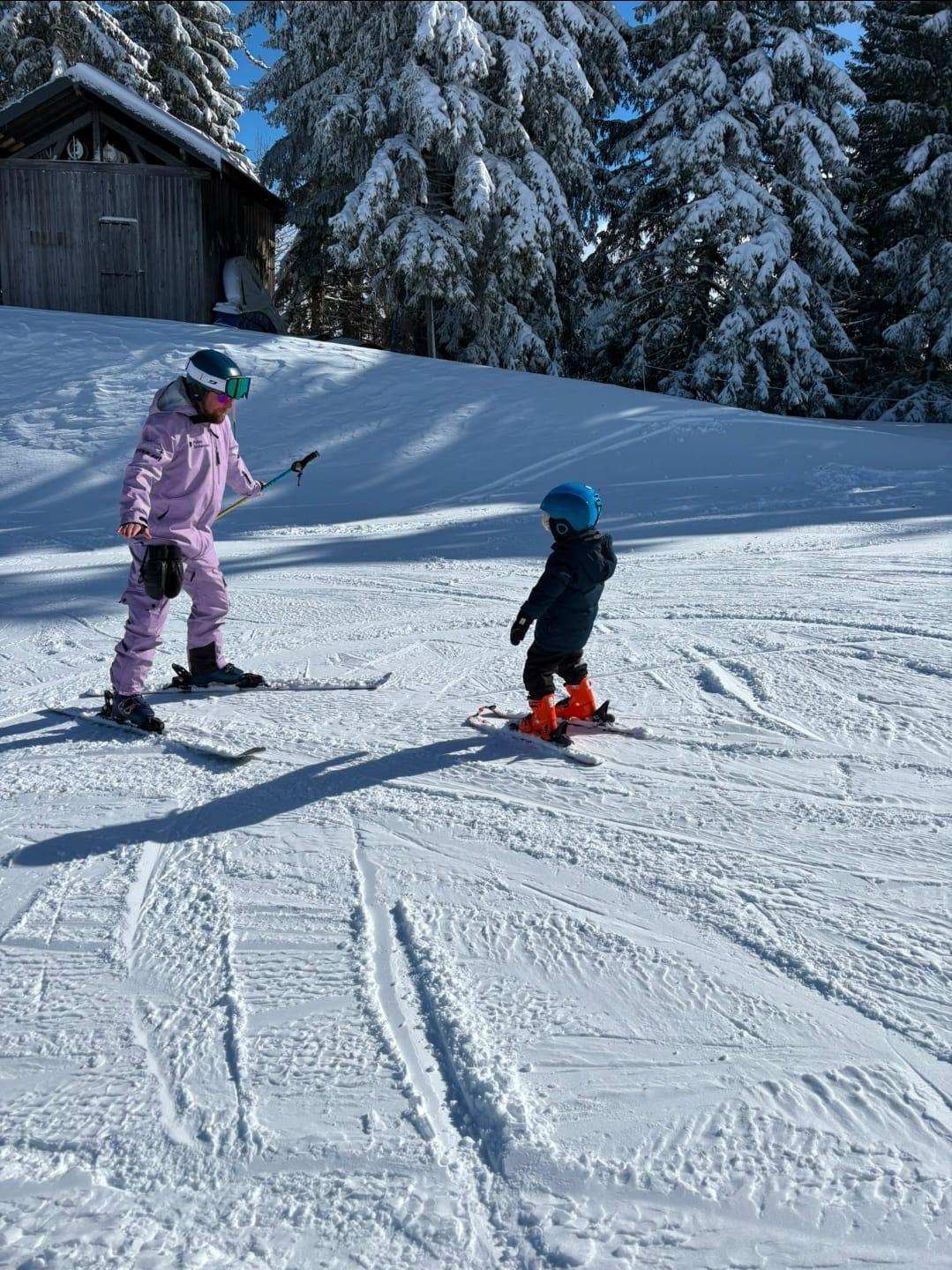 Pulse Snowsports ski instructor delivering a ski lesson to a 3 year old child on the Magic carpet Morzine