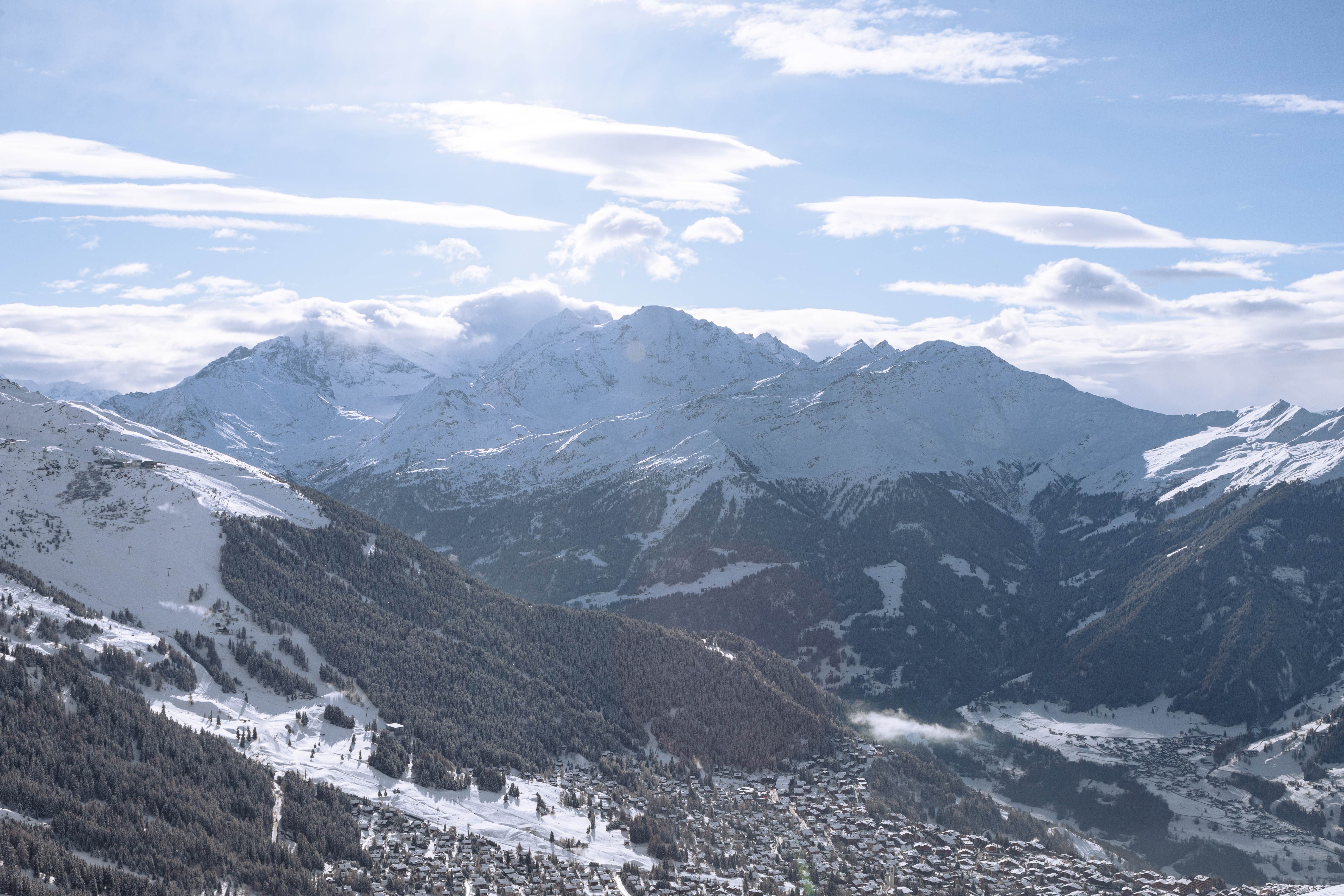 Panoramic view of Verbier ski resort with the 4 Vallées, snow-covered peaks and skiers enjoying the views.