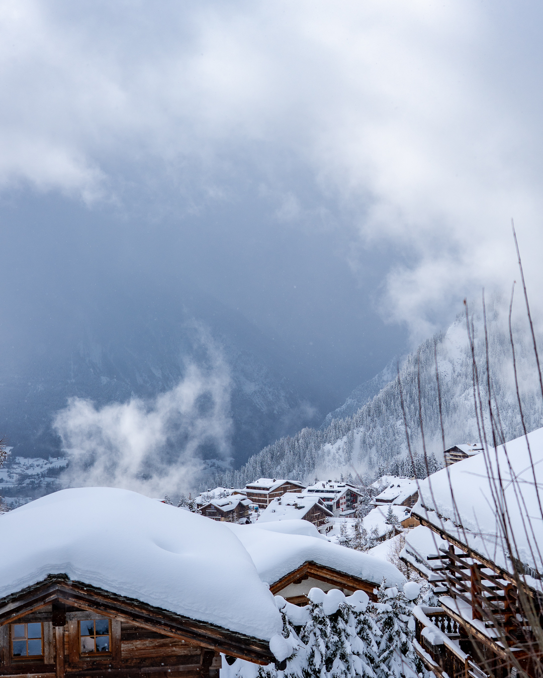 Luxury ski chalet covered in snow in Verbier with mountain views.