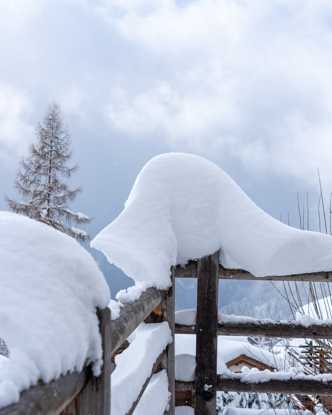Deep snow build-up on a wooden fence following fresh snowfall in Verbier.