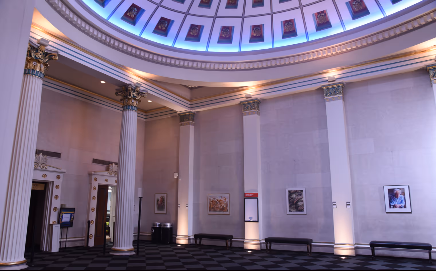 Grand rotunda inside Actors Theatre of Louisville, featuring neoclassical columns and art displays.