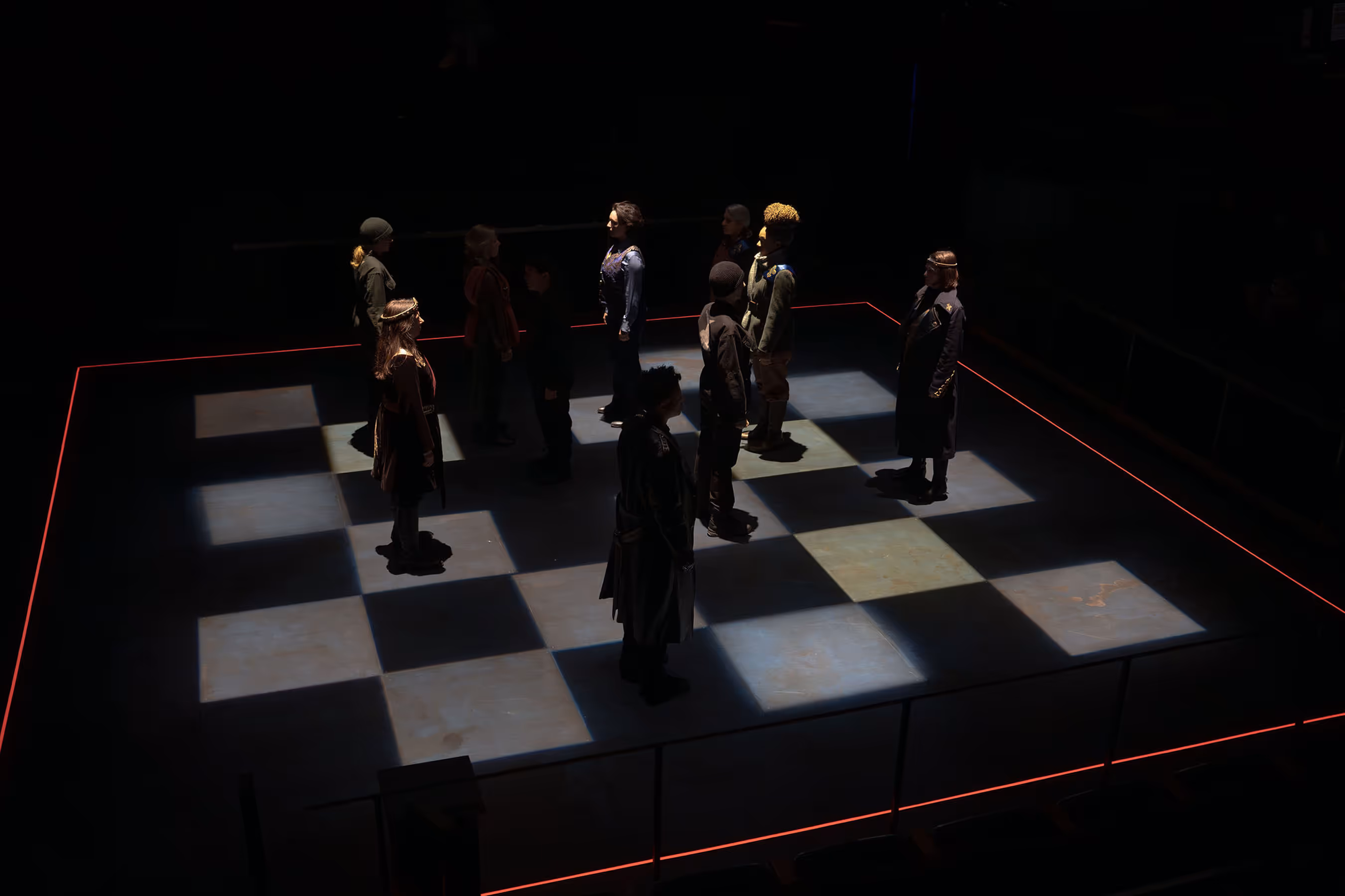 Cast stands in formation on a lit checkerboard stage at Actors Theatre of Louisville, creating bold theatrical imagery.