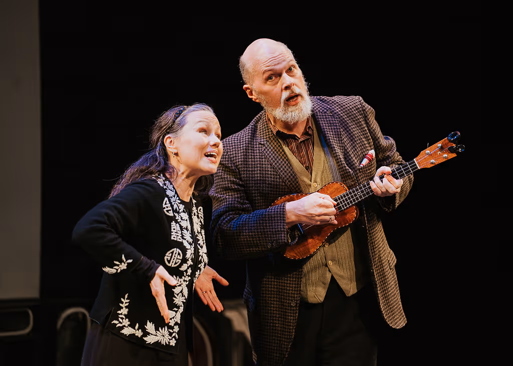 Two actors perform at Actors Theatre of Louisville, one singing and one playing ukulele live on stage.