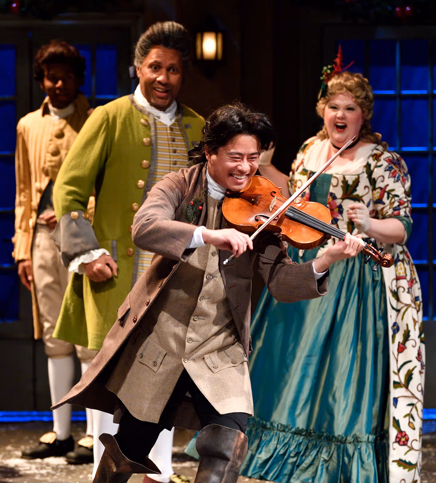 Actors Theatre of Louisville cast in period costumes performing joyful scene with live violin.