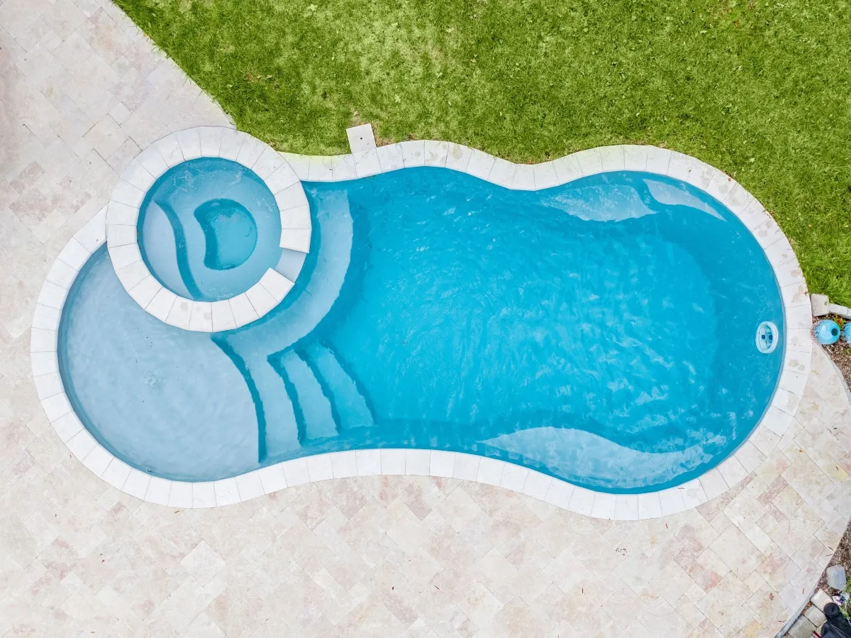 Freeform pool with natural rock waterfall and tanning ledge