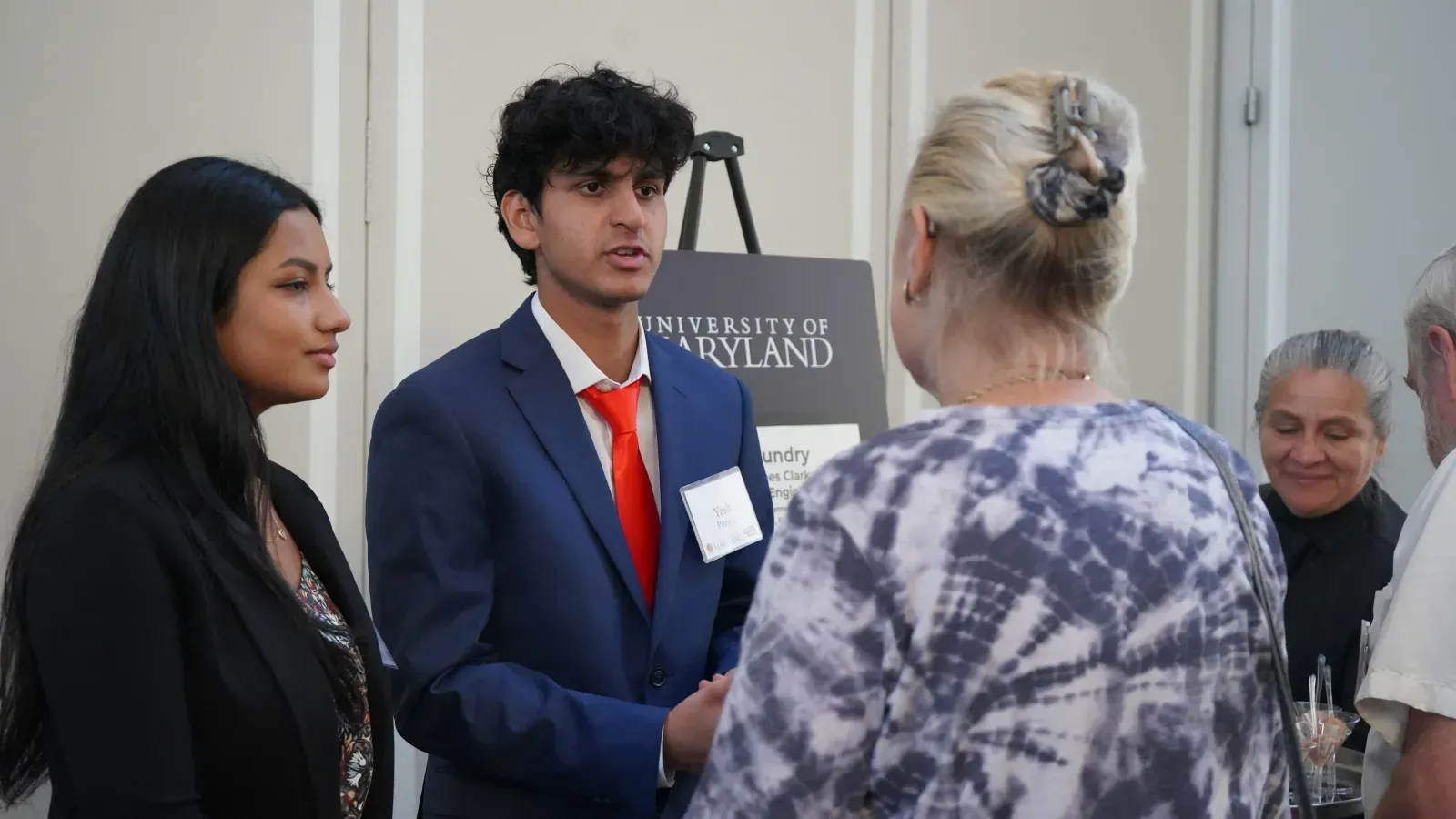 An xFoundry student presenting his work to an event visitor