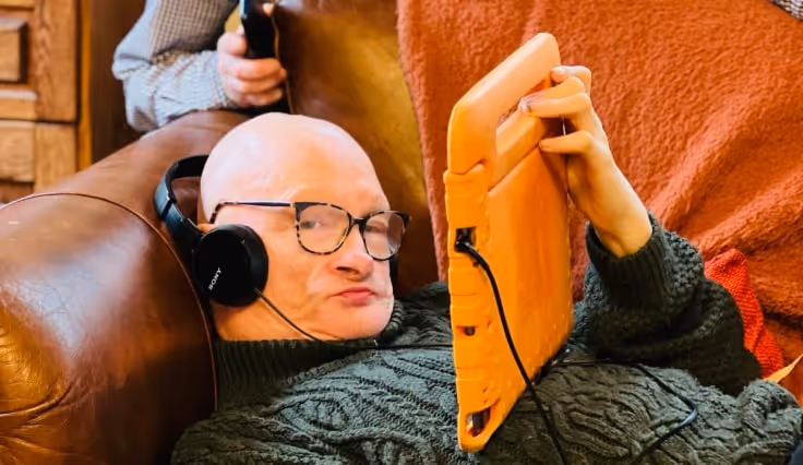 Service user using a tablet and headphones