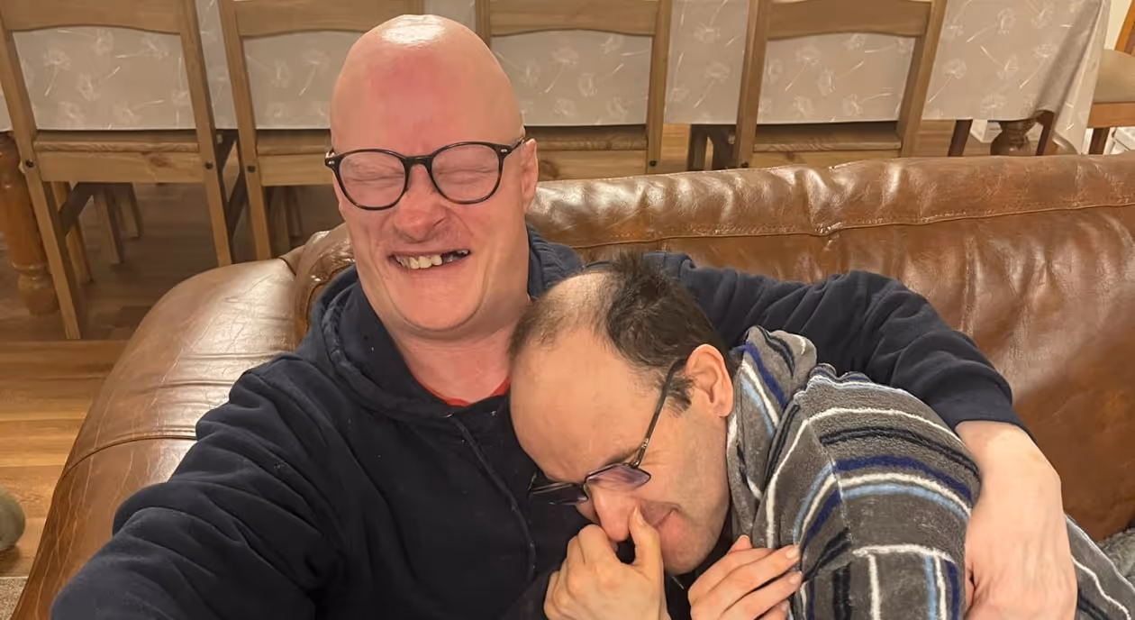 Two service users hugging