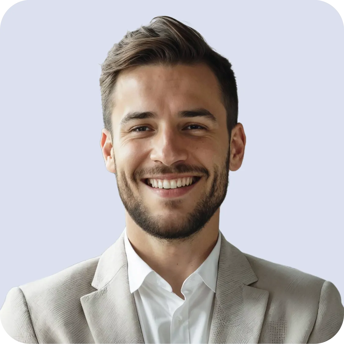 Smiling young man with short brown hair and beard wearing a light gray blazer and white shirt.