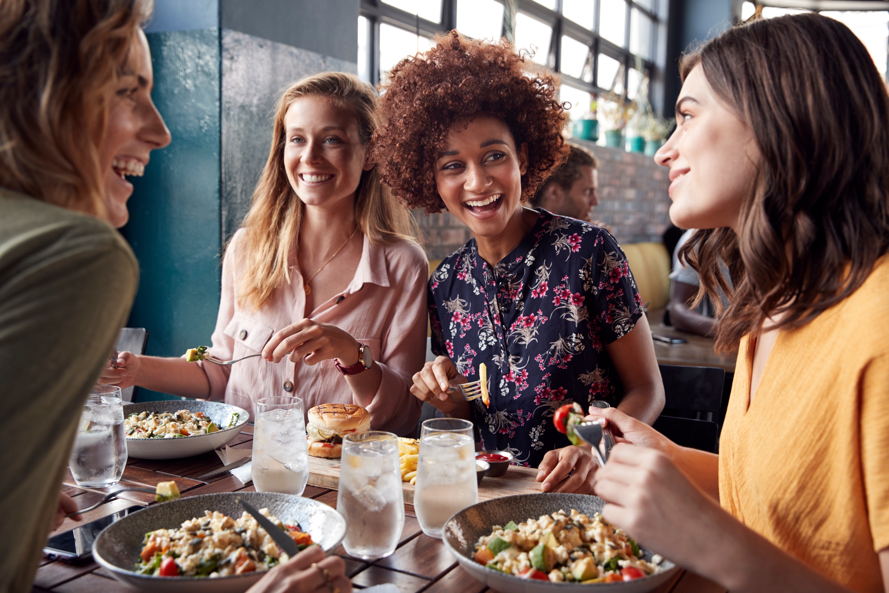 Group of residents enjoying a meal at a local restaurant near Grand at Riverside, highlighting the vibrant dining scene and social lifestyle in the community.
