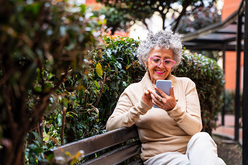 elderly woman smiling at her phone
