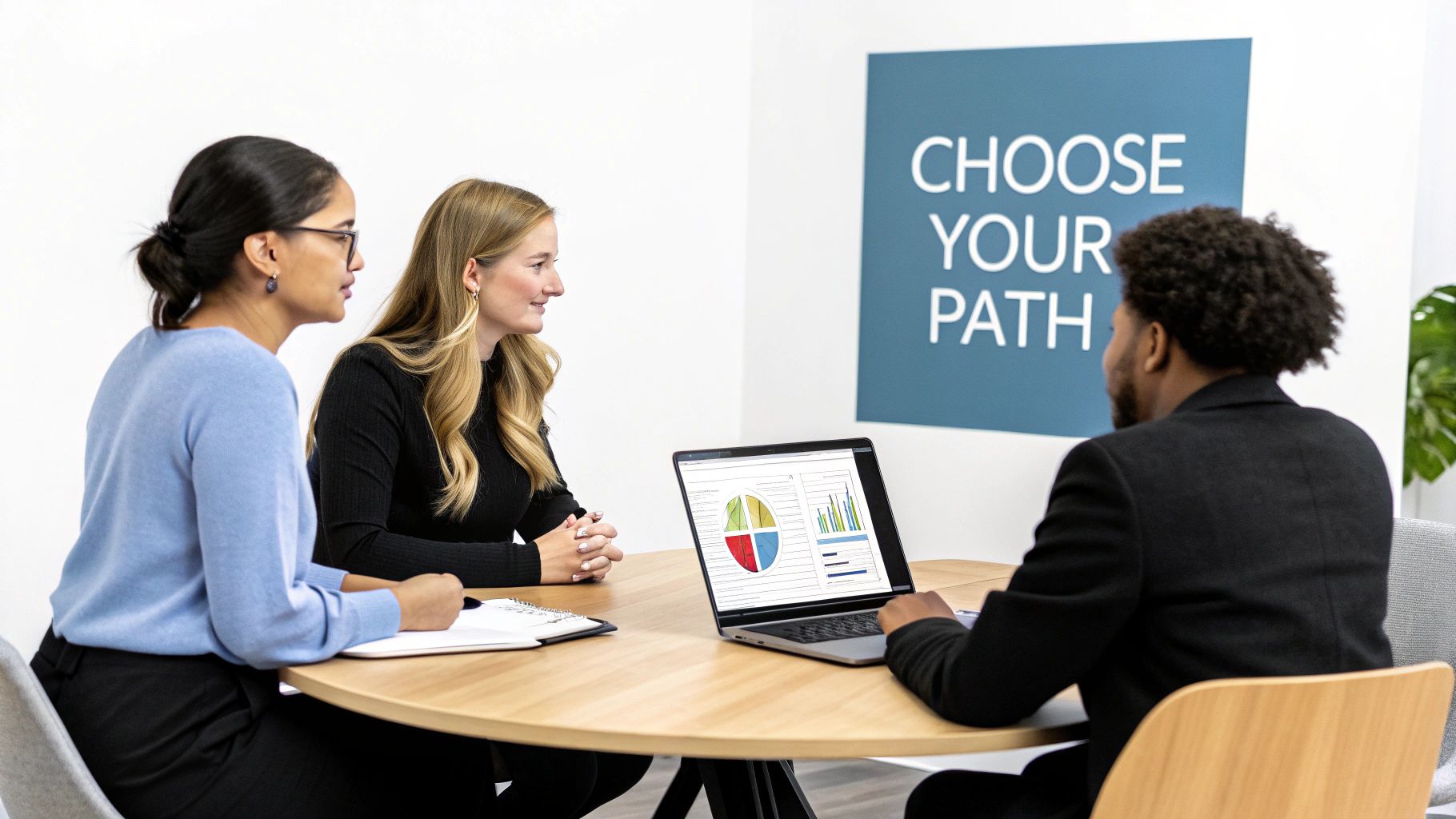 Diverse team in a meeting, analyzing data on a laptop in a bright office environment.