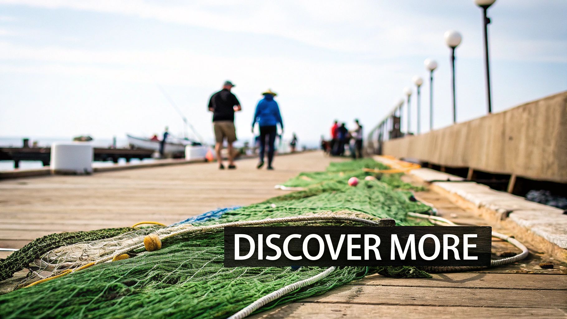 A scenic wooden pier with green fishing nets, people strolling, and a "DISCOVER MORE" sign.