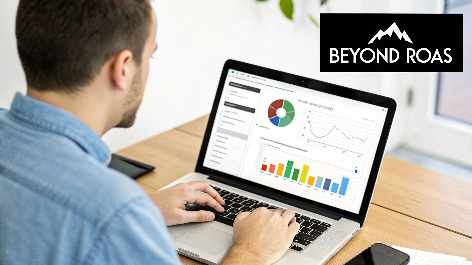 Man working on a laptop displaying business data charts and graphs, with 'Beyond ROAS' logo.