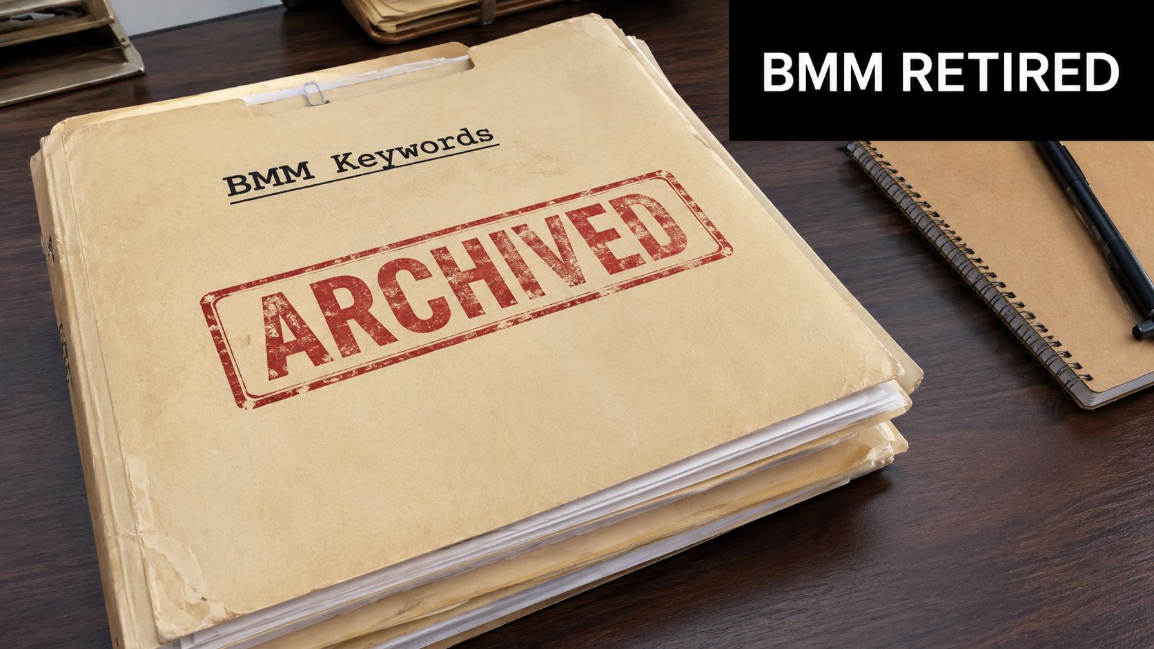 A tan manila folder labeled BMM Keywords with a red stamp reading Archived on a wooden desk.