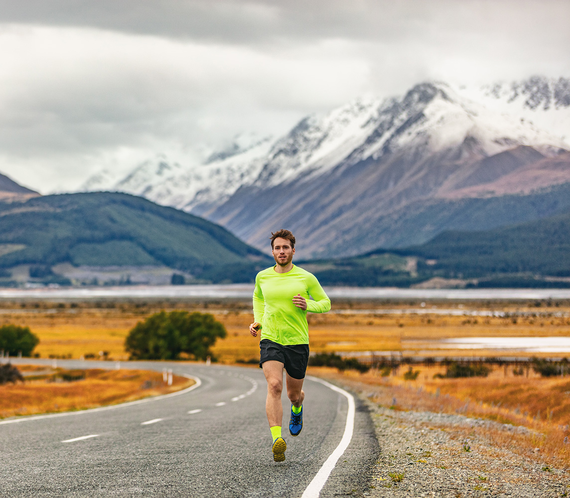 Runner on mountain road in warm conditions