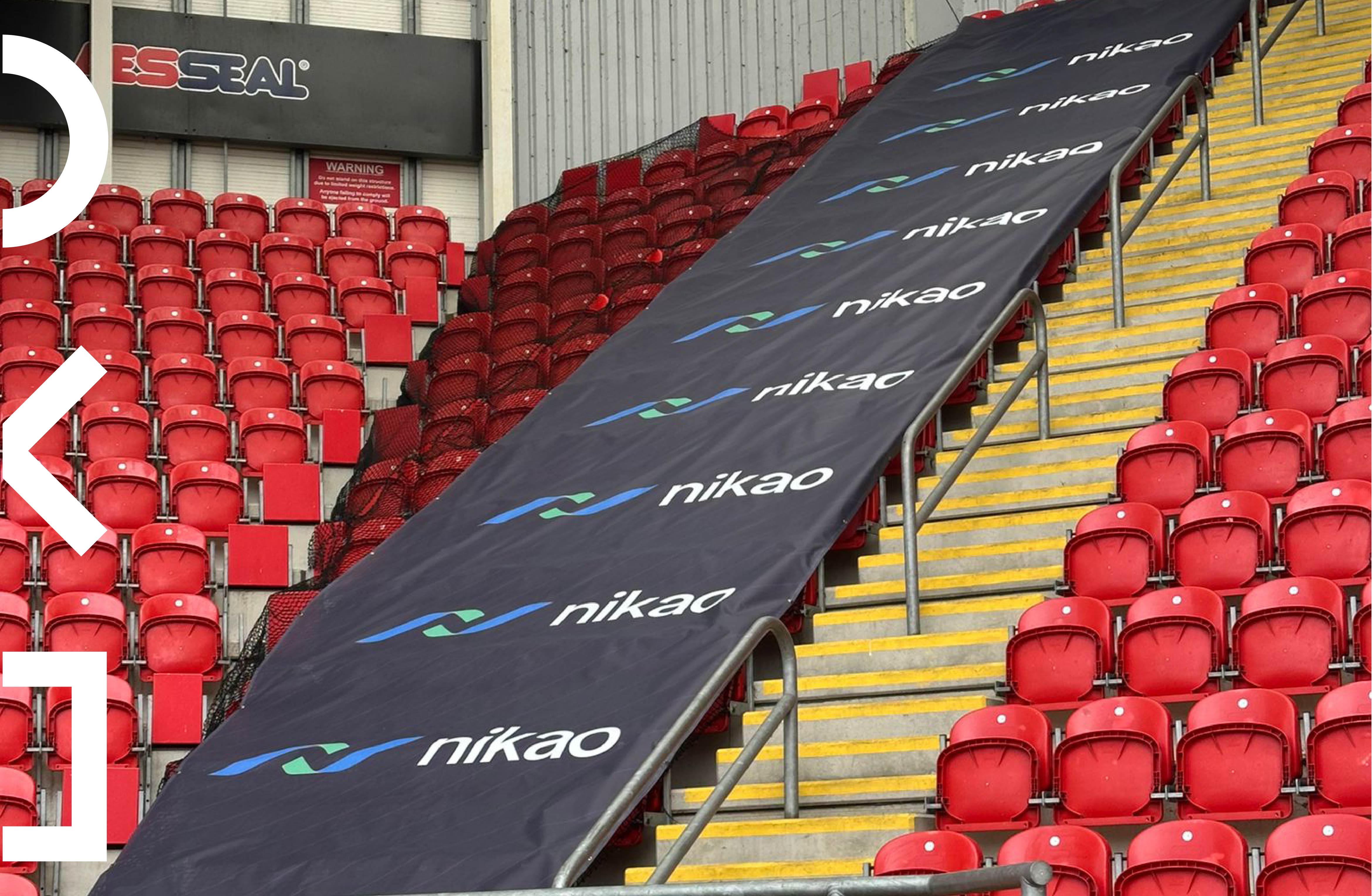 Large format mesh banner installation at Rotherham United stadium acting as branded safety barrier