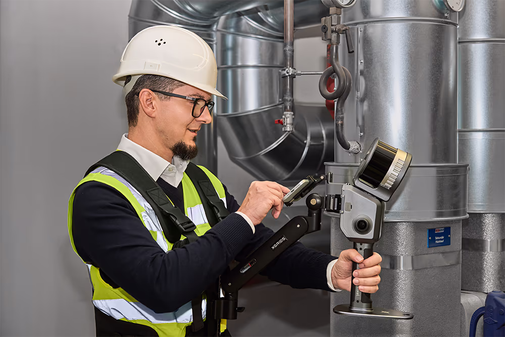 Mitarbeiter von ViConstruct führt mit einem mobilen 3D-Scanner eine digitale Bestandsaufnahme technischer Anlagen durch.  SEO-orientierte Variante:  **ViConstruct Mitarbeiter bei der digitalen Bestandsaufnahme und 3D-Vermessung technischer Anlagen mit mobilem 3D-Scanner.