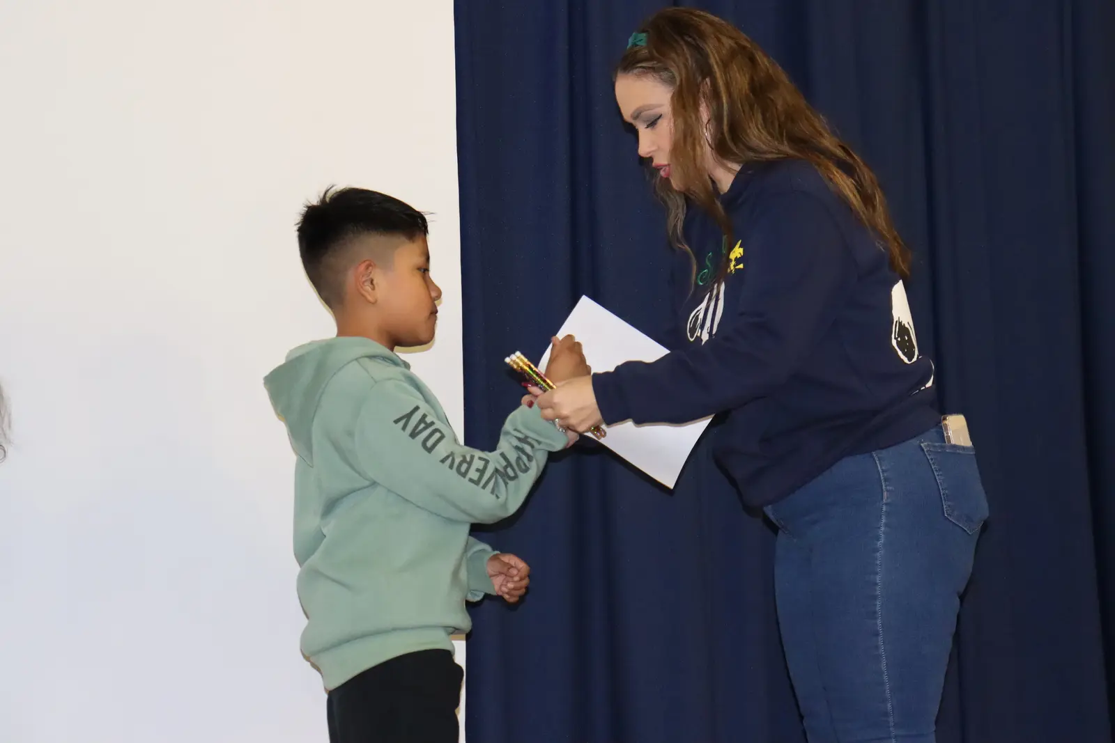 Student receiving certificate from teacher at school ceremony