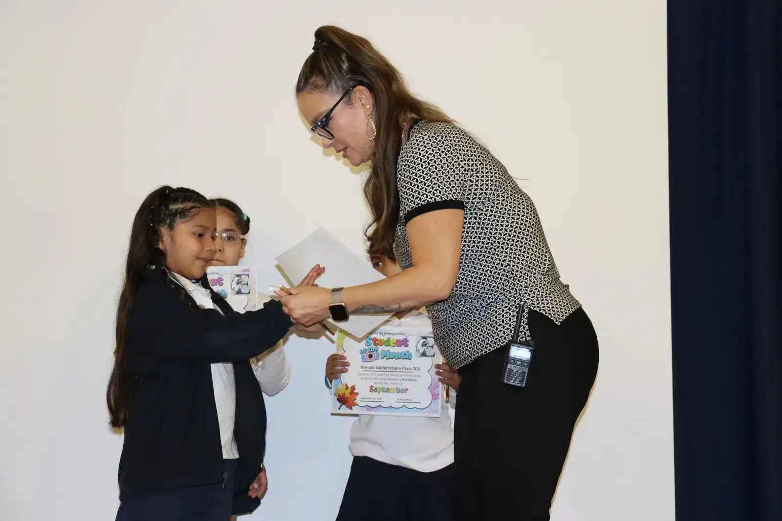 Teacher presenting certificate to student at school ceremony