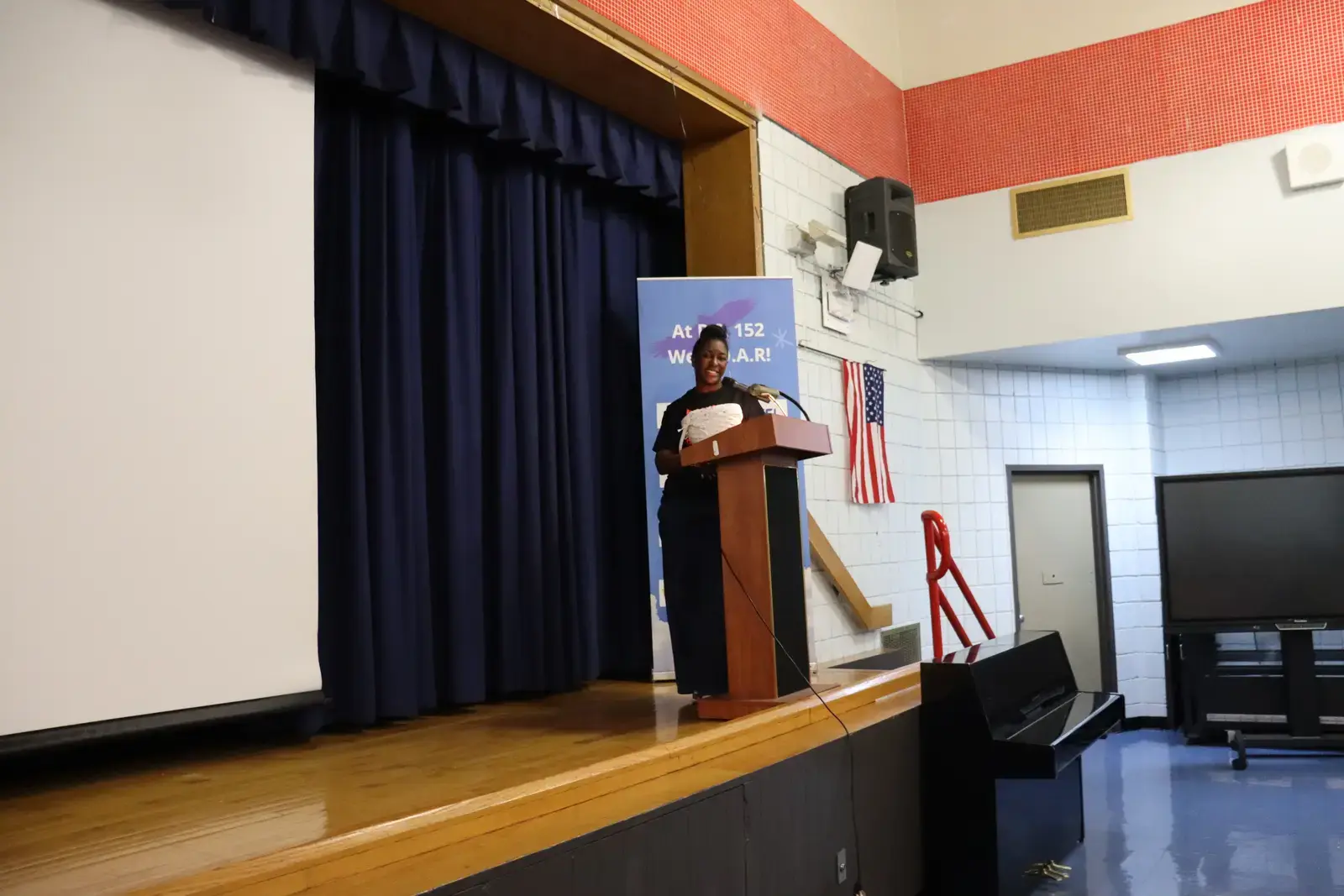 Student speaking at podium during school assembly